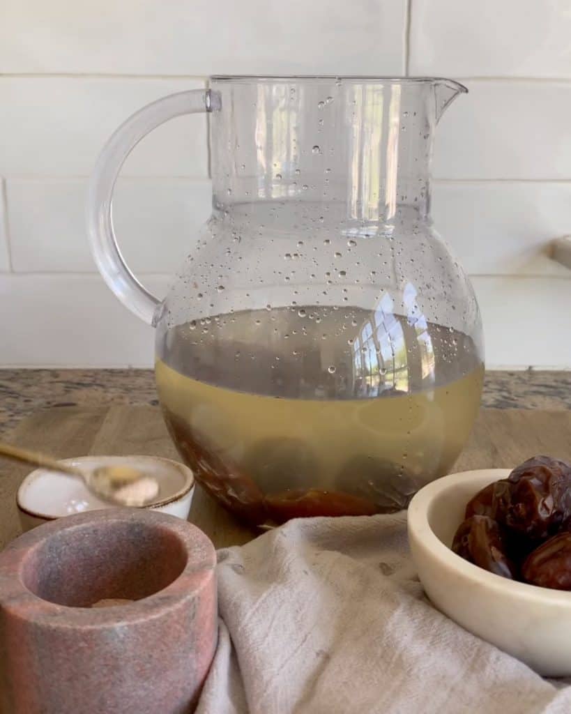 Nabeez- A prophetic drink made with dates or raisins in a jug with a bowl of dates and some pink salt beside it.